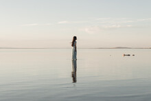 Teenage Girl In Dress Standing In Great Salt Lake During Sunset