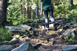 © OneWellStudio - Man climbs mountain steam river. Sporty clothes and backpack. Hiking boots in outdoor action. Top View of Boot on the trail. Close-up Legs In sport trekking shoes on rocky stones of Mountain river