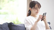 © aijiro - スマートフォンを操作している若い女性