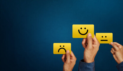 Hand of client show a feedback with smiley face card. Service rating, satisfaction concept