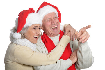 Poster - Portrait of happy senior couple in Santa hats pointing