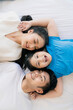 © whyframeshot - Happy Attractive Young asian Family Portrait Healthy harmony in life family day concept asian family man woman and little girl having good time together.top view bedroom mattress