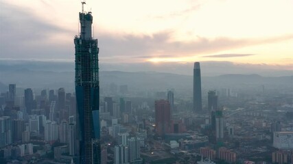 Wall Mural - Establishing aerial cinematic drone b-roll shot of sunset at Kuala Lumpur city skyline. 