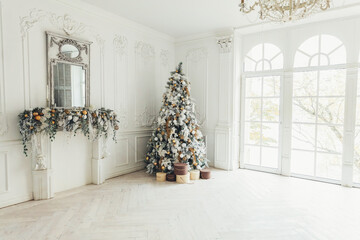 Classic christmas New Year decorated interior room New year tree. Christmas tree with gold decorations. Modern white classical style interior design apartment, large window. Christmas eve at home.