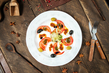 Top view on gourmet caprese salad in a white plate