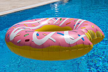 Poster - pink inflatable donut doughnut floating mattress in swimming pool. Beach pool accessories. Summer holiday concept