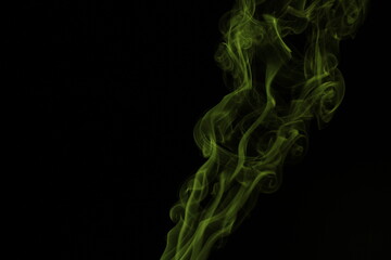 yellow smoke from incense on a black background