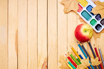 Wall Mural - back to school concept. education and study stationery on a wooden desk. above view. decorated with yellow maple leaves