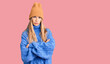 © Krakenimages.com - Beautiful caucasian woman with blonde hair wearing wool sweater and winter hat skeptic and nervous, disapproving expression on face with crossed arms. negative person.