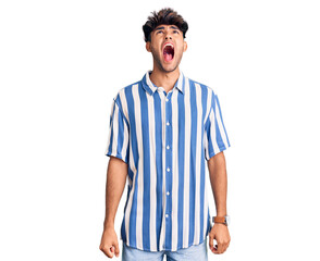 Young hispanic man wearing casual clothes angry and mad screaming frustrated and furious, shouting with anger. rage and aggressive concept.