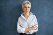 © Anatoliy Karlyuk - People, job, career and aging. Confident attractive European 50 year old female real estate agent in elegant clothing posing isolated with arms folded on chest, her posture expressing confidence