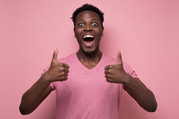 Sticker - Handsome black man showing thumb up with cheerful attitude on pink background