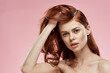 Pretty woman with long beautiful hair grooming hairstyle glamor naked shoulders pink background