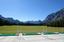 Gorgeous Driving Range Surrounded By Forest And Big Mountains In The Background, On A Beautiful Sunny Day In Kananaskis, Alberta, Canada.