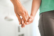 © Pixel-Shot - Couple holding hands together at home, closeup