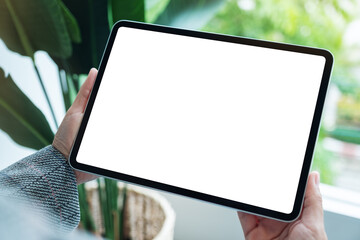 Mockup image of a woman holding digital tablet with blank white desktop screen