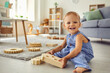 © Studio Romantic - Cute little kid looking at camera smiling happily while playing in cozy nursery room