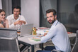 © zinkevych - Bearded male sitting at table opposite his male and female coworkers
