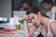 © zinkevych - Exhausted brown-haired female sitting at meeting, resting her head on her hand