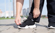 © dark_blade - woman fastening shoe-laces on her trainers the sports ground