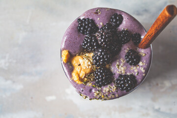 Wall Mural - Berry smoothie with peanut butter and hemp seeds in glass, top view. Healthy vegan food concept.