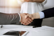 © rogerphoto - Business people shaking hands finishing contract signing in sunny office, close-up. Handshake and marketing