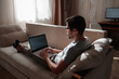 © Seleznov_Molchanova - Remote Job. Man Working On Laptop Sitting On Sofa At Home.