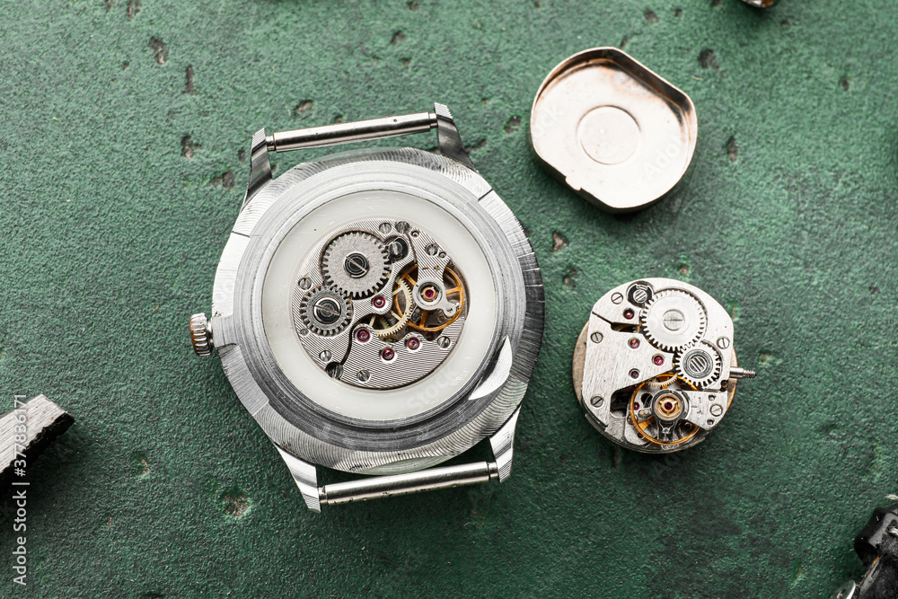 Watch and tools for repair on color background