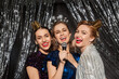 © Syda Productions - holidays, friends and people concept - three women s with microphone singing karaoke at christmas party