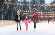 © Syda Productions - christmas, family and leisure concept - happy mother, father and daughter at outdoor skating rink in winter