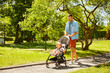 © Syda Productions - family, fatherhood and people concept - happy father with child in stroller walking at summer park
