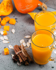 Wall Mural - Natural homemade spicy autumn pumpkin juice in glass mugs on a gray table