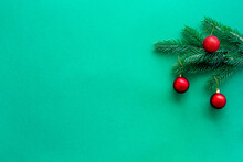 Christmas Red Bauble On A Fir Branch On Green Background