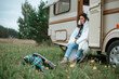 Girl sitting on the camper ladder with a mug in her hands wrapped in a blanket
