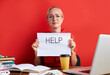 © alfa27 - overworked unhappy and frustrated young caucasian woman in stress sitting at office desk, she has a lot of tasks in work, deadline, isolated red background