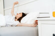 © Drobot Dean - Image of pleased beautiful girl stretching her body while lying in bed