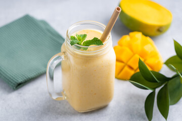 Wall Mural - Tasty vegetarian mango smoothie in a glass with bamboo drinking straw