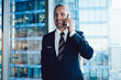 © BullRun - Businessman in blue suit speaking to colleague on smartphone with content  smile