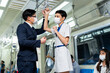 © NVB Stocker - Business man and woman greeting on Urban Public Transport Metro. Asian people go to work by public transport. Face Mask protection against virus. Covid-19, coronavirus pandemic