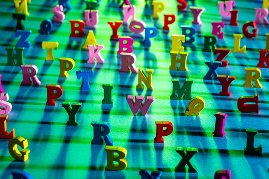 Latin characters with focus in the center. English letters stand on a green background and cast shadows. The letters of the alphabet in random order. The concept of Literacy on a green background.