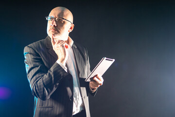 Poster - A person is thinking and holding a tablet computer. A scientist with an electronic tablet in his hands. Getting data for a new project using an electronic tablet.
