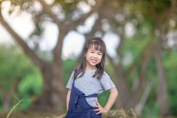 Blurred abstract background of Asian girls, cute in a bright dress, playing on the street or in a park, when parents watch closely.