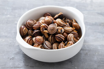 Canvas Print - boiled snails in the white bowl on ceramic background