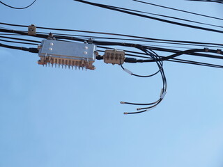 Internet network metal boxes and cable connectors. There are communication and low voltage cables on top. On a clear blue sky background. Focus close and choose the subject