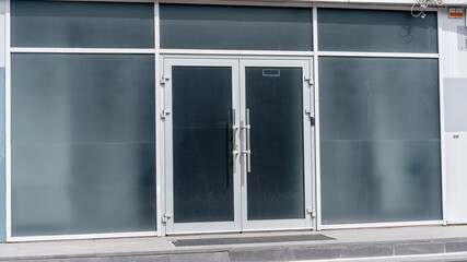 empty gray wall with cord for guard alarm and door way on city street