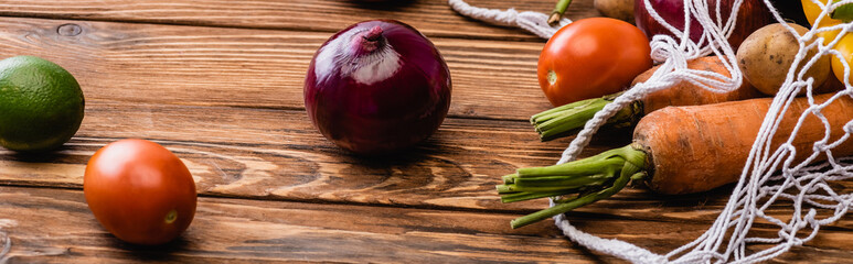 Wall Mural - fresh ripe vegetables scattered from string bag on wooden table, panoramic shot