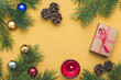 © tatyana - Golden Christmas background with pine tree branches and holiday decorations. Still life. Bright yellow flat composition. Celebration frame border, mockup with empty space for text. Festive template.