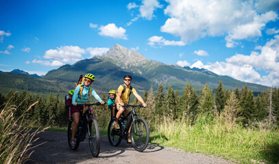 Wall Mural - family with small children cycling outdoors in summer nature.