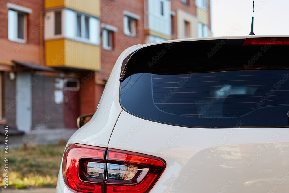 Back window of white car parked on the street in summer sunny day, rear ...