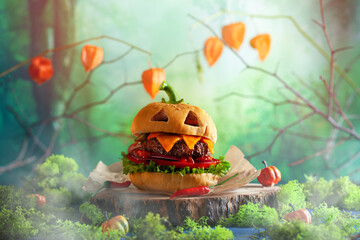 Wall Mural - Halloween party burger in shape of scary pumpkin   on natural wooden board. Halloween food concept.